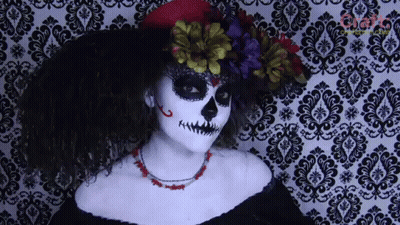 Woman In Day Of The Dead Costume In Front Of Damask Wall GIF
