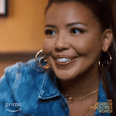 Woman In Denim Jacket And Hoop Earrings Smiling For The Horror Of Dolores Roach GIF