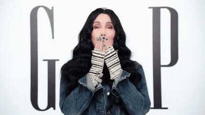 Woman In Denim Jacket Blowing A Kiss Gap Sign GIF