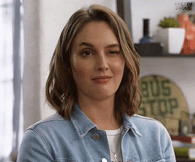 Woman In Denim Jacket Smiling And Winking GIF