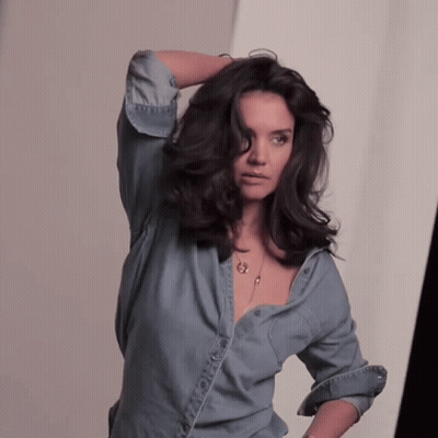 Woman In Denim Shirt Holding Hair GIF