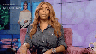 Woman In Denim Shirt Sitting In Pink Chair Making Face GIF