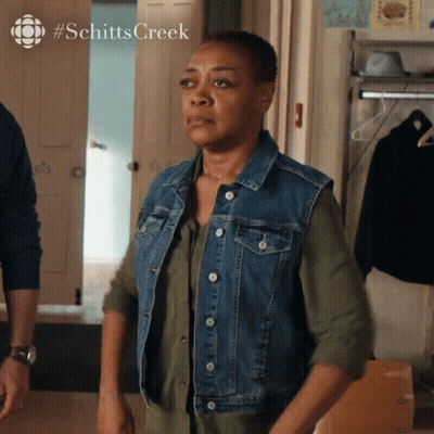 Woman In Denim Vest At Schitts Creek Door GIF