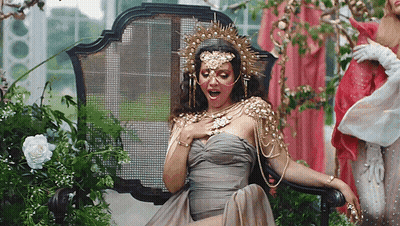 Woman In Dress And Crown Sitting In Chair GIF