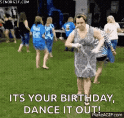Woman In Dress Dancing In Grass While Group Watches GIF