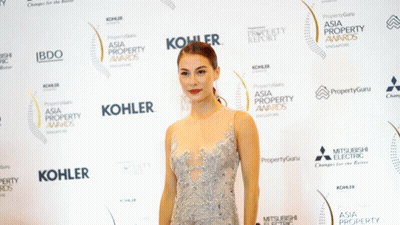 Woman In Dress In Front Of Kohler Sign GIF