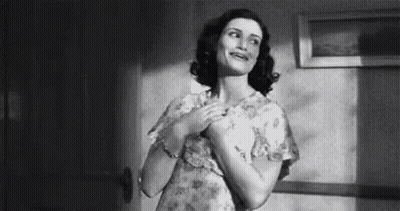 Woman In Dress Standing With Hands On Chest GIF