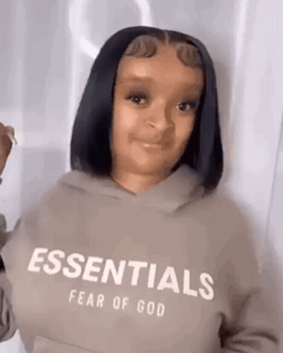 Woman in Essentials Fear of God Hoodie Making Funny Face