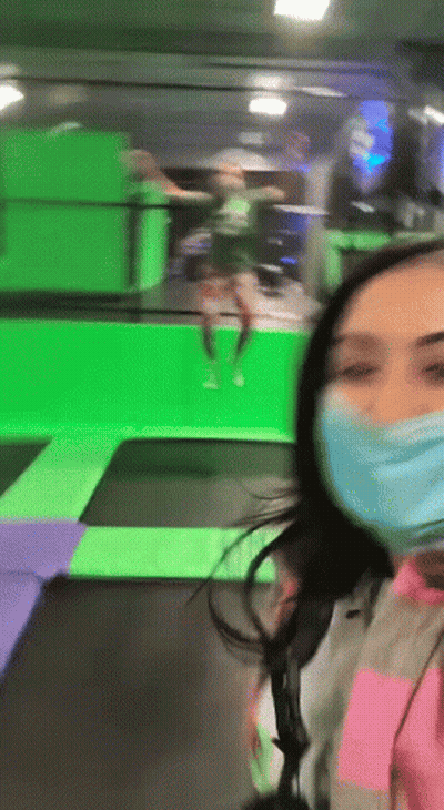 Woman In Face Mask Standing In Front Of Trampoline GIF