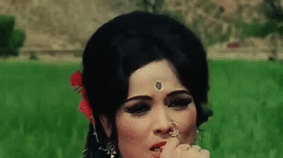 Woman In Field With Flower In Hair And Nose Ring GIF