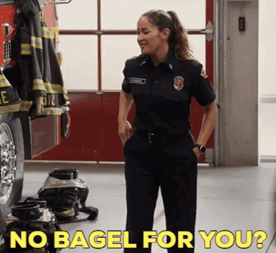 Woman In Firefighter Uniform In Front Of Fire Truck GIF