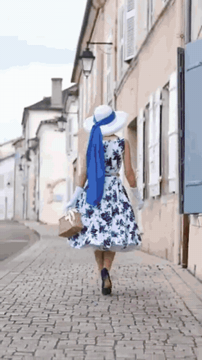 Woman In Floral Dress And White Hat Walking GIF
