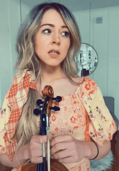 Woman In Floral Dress Holding Violin GIF