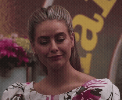 Woman In Floral Dress In Front Of Y2 Sign GIF