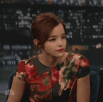 Woman In Floral Dress Sitting At Microphone GIF
