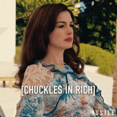 Woman In Floral Dress Sitting In Front Of Chuckles In Rich Sign GIF