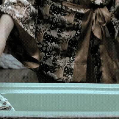 Woman In Floral Dress Standing In Front Of Green Box GIF
