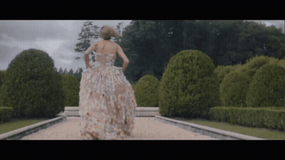 Woman In Floral Dress Walking Down Path GIF