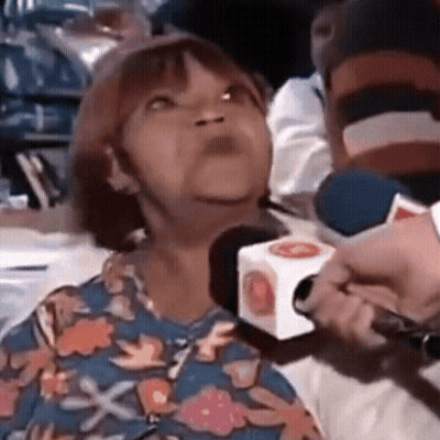 Woman In Floral Shirt Interviewed By Man With Microphone GIF