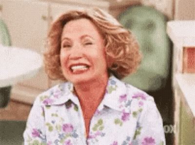 Woman In Floral Shirt Laughing With Eyes Closed GIF