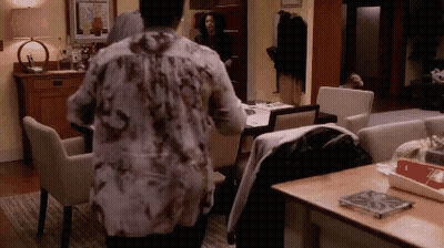 Woman In Floral Shirt Looking At Table GIF