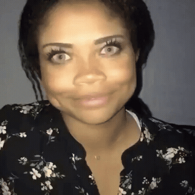 Woman In Floral Shirt Smiling And Making Face GIF