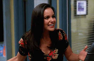 Woman In Floral Shirt Smiling And Waving Hand GIF