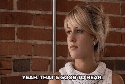 Woman In Front Of Brick Wall Saying Yeah That's Good To Hear GIF