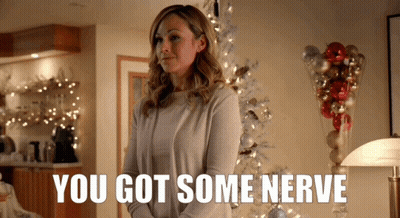 Woman In Front Of Christmas Tree Saying You Got Some Nerve GIF