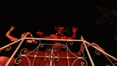 Woman In Front Of Devil Statue With Horns GIF