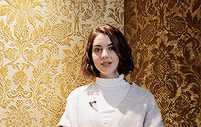 Woman In Front Of Gold Patterned Wall GIF