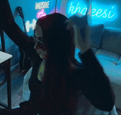 Woman In Front Of Hustle And Khaleesi Neon Sign GIF