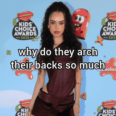 Woman In Front Of Nickelodeon Sign Says Why Do They Arch Their Backs GIF