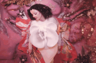 Woman In Front Of Pink Wall With White Flower GIF