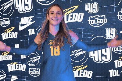 Woman In Front Of Wall With Toledo Logos GIF