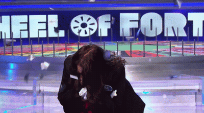 Woman In Front Of Wheel Of Fort Sign GIF