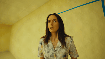 Woman In Front Of Yellow Wall GIF