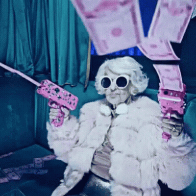 Woman In Fur Coat And Sunglasses Holding Pink Gun GIF