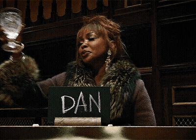 Woman In Fur Coat Holding Glass And Sign Saying Dan GIF