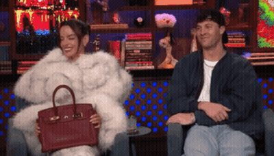 Woman In Fur Coat Holding Red Handbag Beside Man GIF
