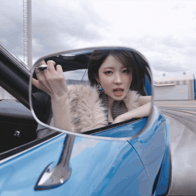 Woman In Fur Coat Looking In Rear View Mirror GIF