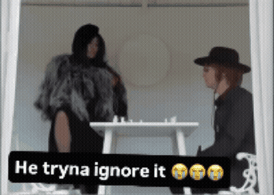 Woman In Fur Coat Next To Man In Black Hat Saying He Tryna Ignore It GIF