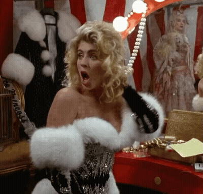 Woman In Fur Coat With Pearl Necklace In Front Of Mirror GIF