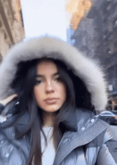 Woman In Fur Hooded Jacket Walking Down Street GIF