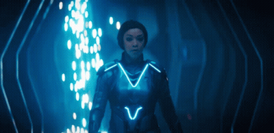 Woman In Futuristic Suit In Dark Room With Blue Light GIF