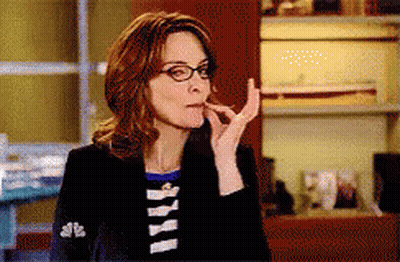 Woman In Glasses And Black Jacket With NBC On Sleeve GIF