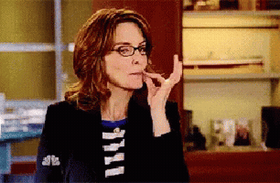 Woman In Glasses And Black Jacket With NBC Sleeve GIF
