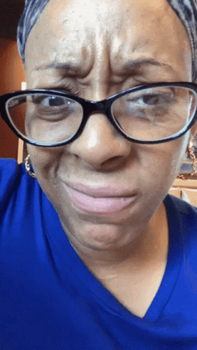 Woman In Glasses And Blue Shirt Making A Face GIF