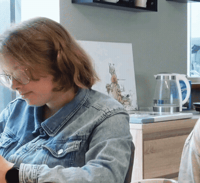 Woman In Glasses And Denim Jacket At Desk GIF