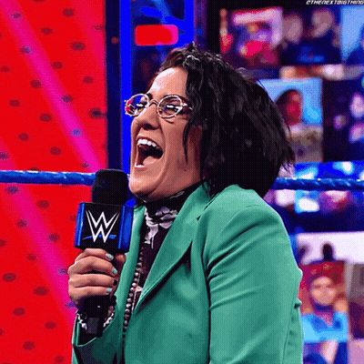 Woman In Glasses And Green Jacket Holding Microphone With W GIF